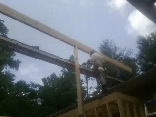 Carpenter setting a ridge beam over a new addition frame — Ice Dam Removal by Roofing Brothers in Beach Haven